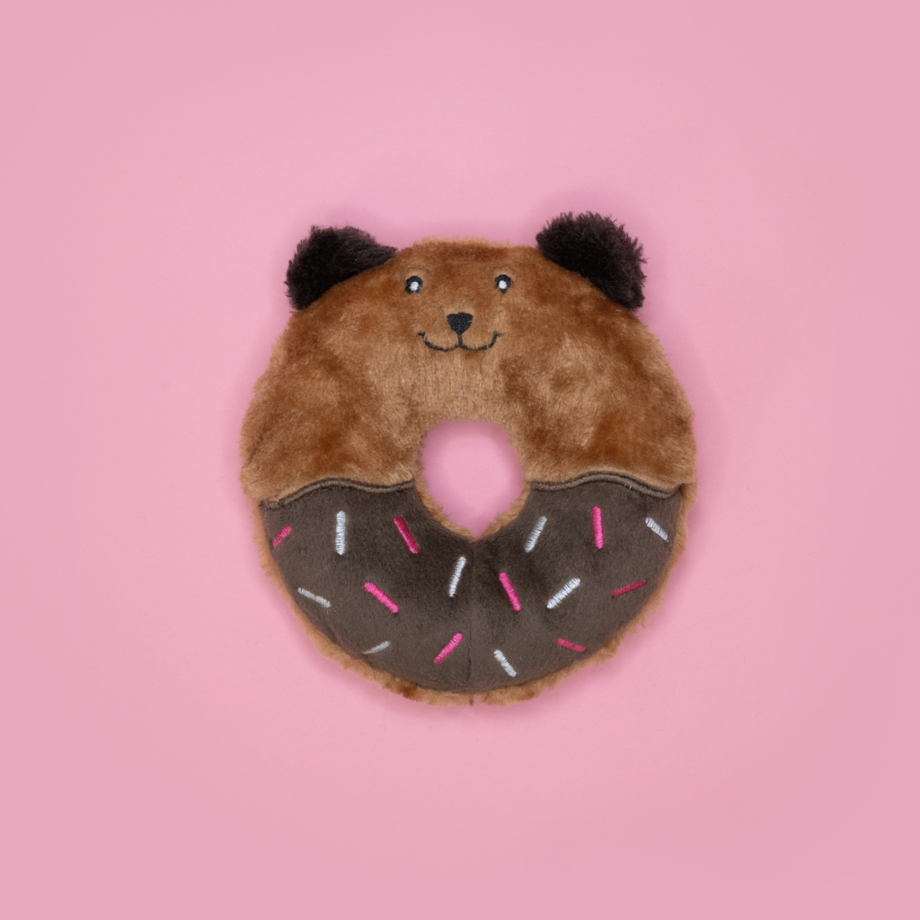 Donutz Buddies - Bear shaped like a bear's face with a donut hole in the middle, decorated with chocolate frosting and colorful sprinkles, against a pink background.