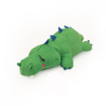 A green, plush **Snooziez with Shhhqueaker - Alligator** with a ribbed texture and blue spikes along its back. The toy has a stitched, smiling face and white, felt teeth.