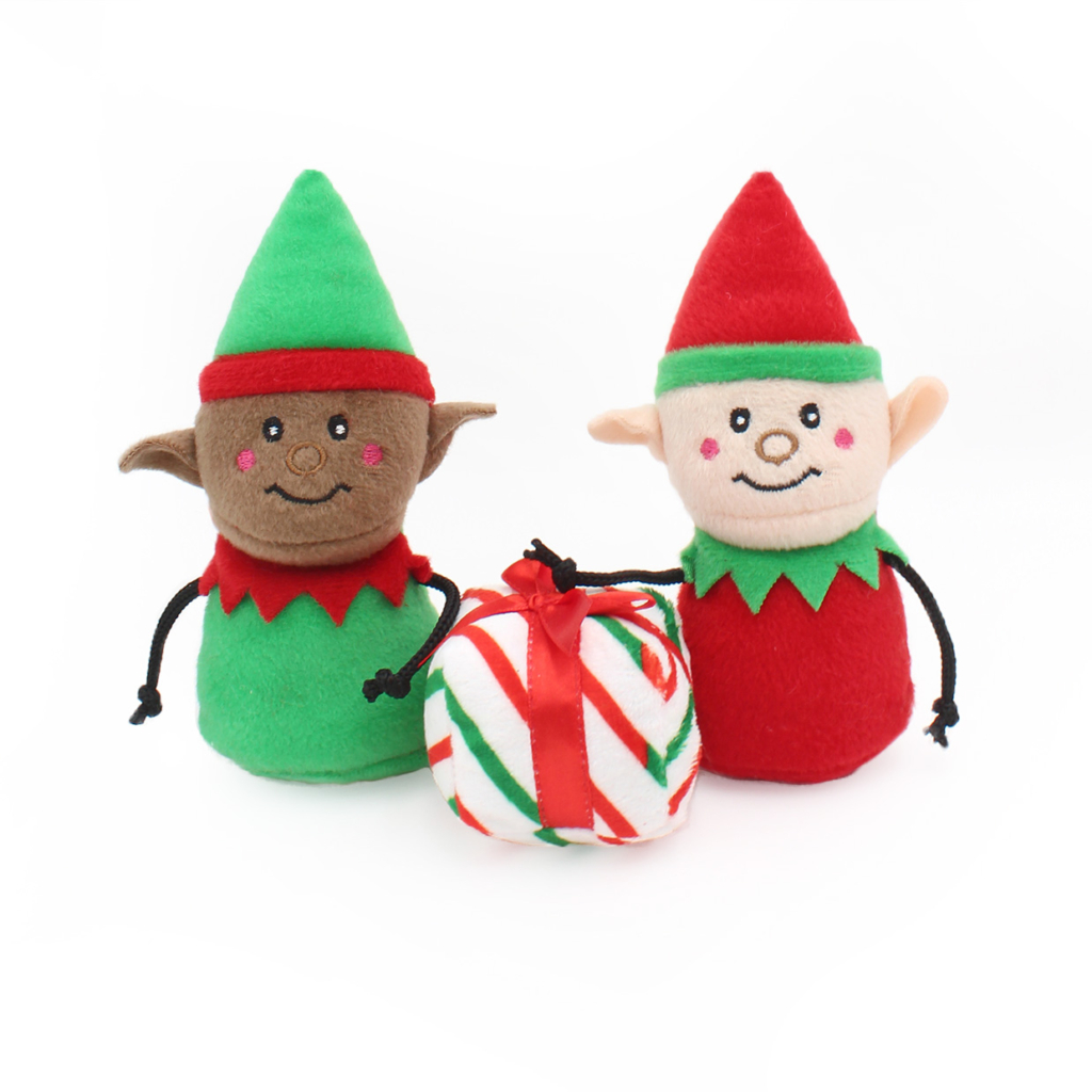 Two Holiday Burrow® - Santa's Workshop toys, one in green and the other in red, stand beside a small, striped gift wrapped with a red ribbon.