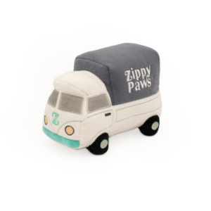 A small, stuffed plush toy shaped like a white and blue delivery truck with "ZippyPaws® Wagon" written on the gray covered portion.