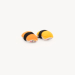 Two small ZippyClaws® NomNomz® - Sushi resembling sushi rolls with orange and yellow tops, wrapped in black bands, placed against a white background.