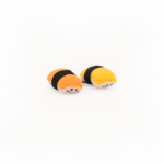 Two ZippyClaws® NomNomz® - Sushi resembling pieces of sushi, with orange and yellow tops, black bands around the middle, and cute faces.