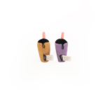 Two plush toys shaped like boba tea drinks, one brown and one purple, each with a straw and product tags attached: ZippyClaws® NomNomz® - Milk Tea and Taro.