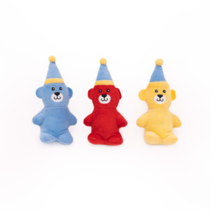 Three Miniz 3-Pack - Birthday Bears wearing blue and yellow hats are lined up. The bears are colored blue, red, and yellow, respectively, from left to right.