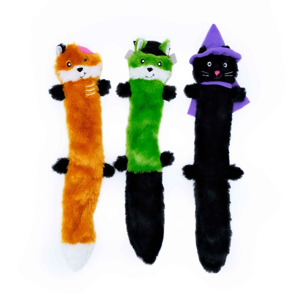 Three Halloween Skinny Peltz 3-Pack Large with different costumes: one orange with a pink hat, one green with a headband, and one black with a purple witch hat.