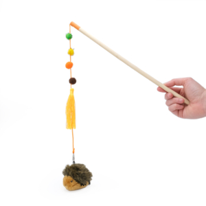 A hand holds a ZippyClaws® ZippyStick - Hedgehog with colorful pom-poms and a plush hedgehog attached by a string, against a white background.