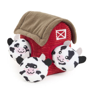 A Zippy Burrow® - Zippy Meal toy with a red plush barn and brown roof, featuring three plush cow heads with black spots and pink cheeks popping out of its openings.