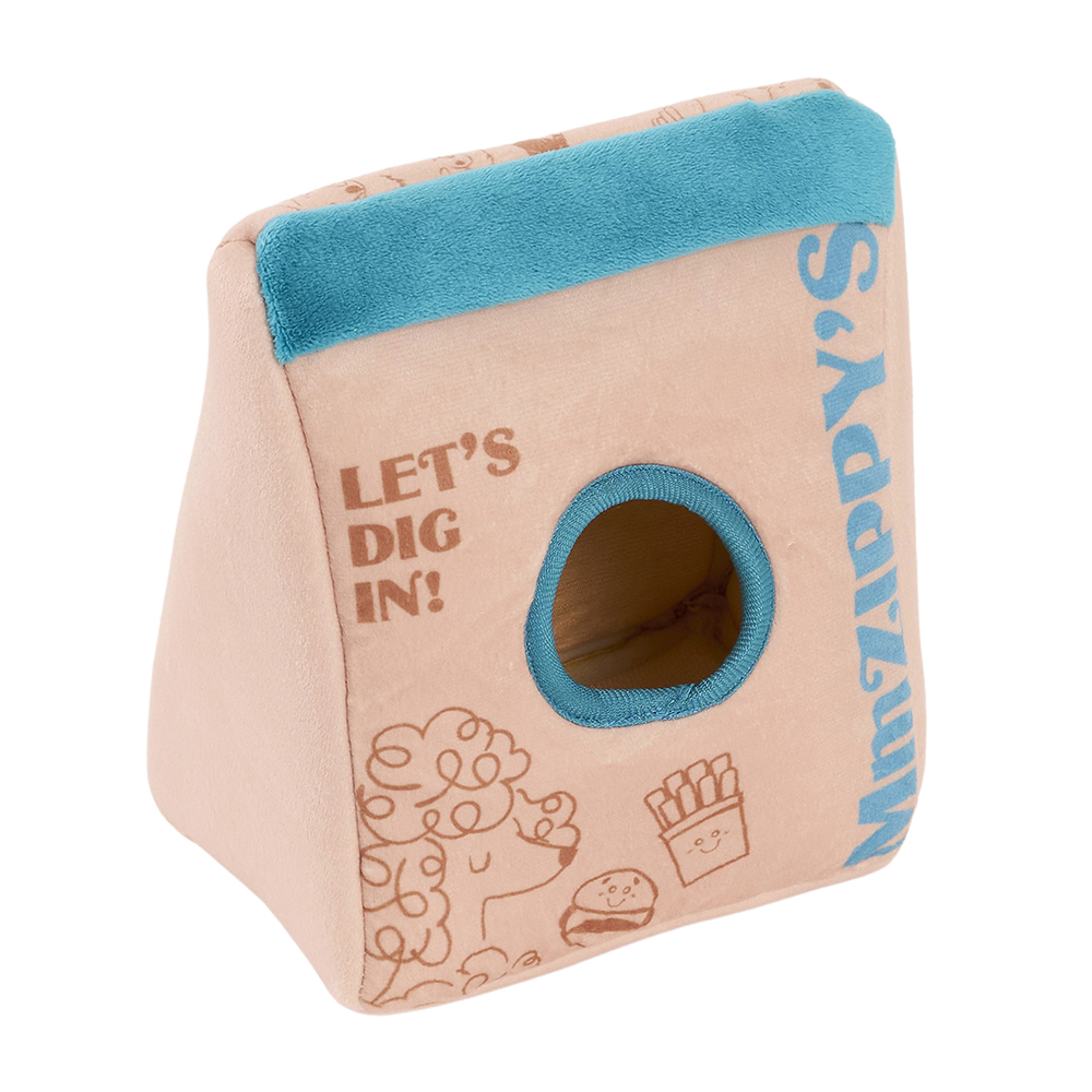 Zippy Burrow® - Zippy Meal is a plush toy designed to look like a brown bag with a teal top, featuring a round hole in the center and adorned with playful food-themed illustrations and the text “LET’S DIG IN!” and “MmZIPPY’S.”.